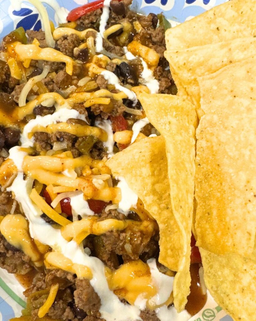 Ground beef taco bowl with melted cheese and tortilla chips