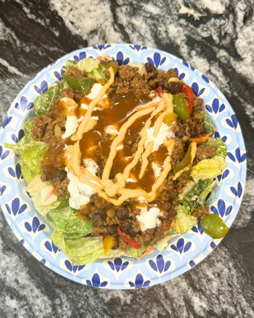 Taco salad with seasoned ground beef, lettuce, cheese, and toppings