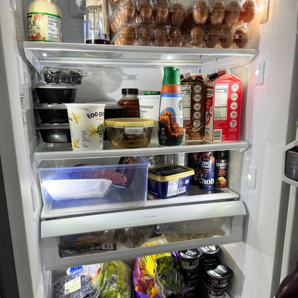 Fridge stocked with repeat grocery staples for a weekly dinner rotation