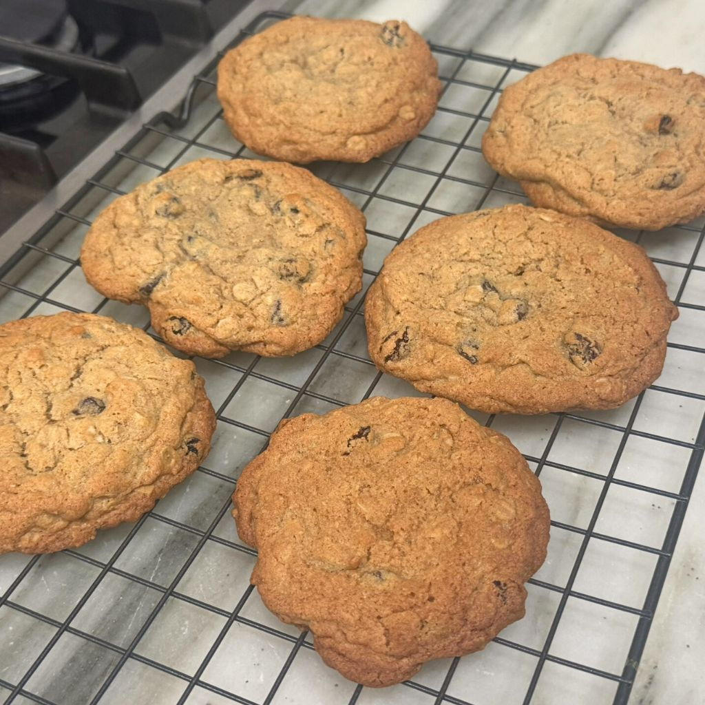 Freshly baked oatmeal raisin cookies on baking sheet