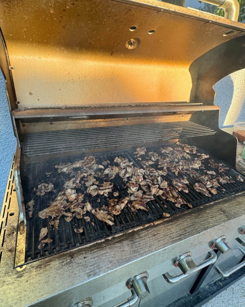 Shabu shabu beef cooking on a grill.