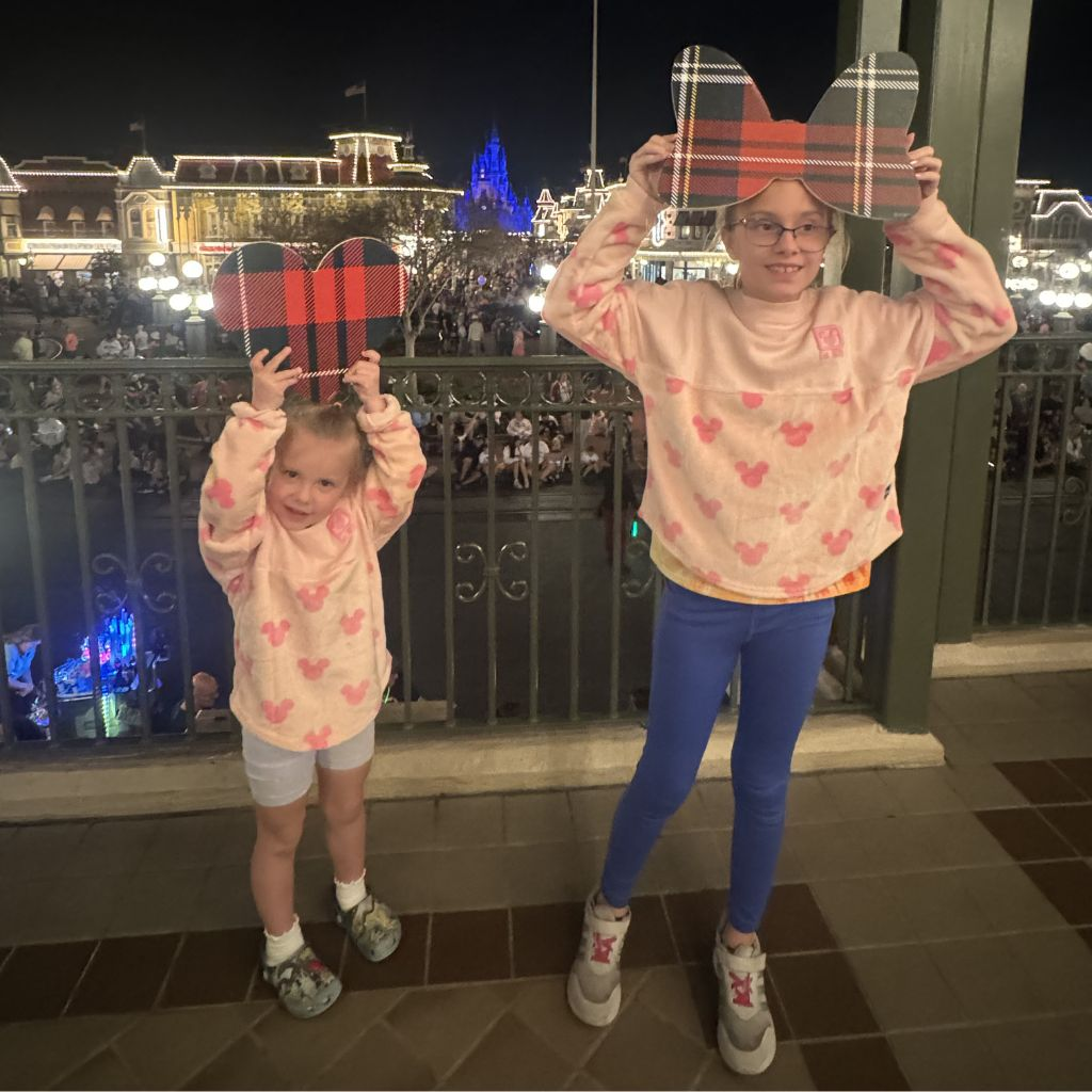 Children holding Mickey ear signs while watching the Magic Kingdom parade