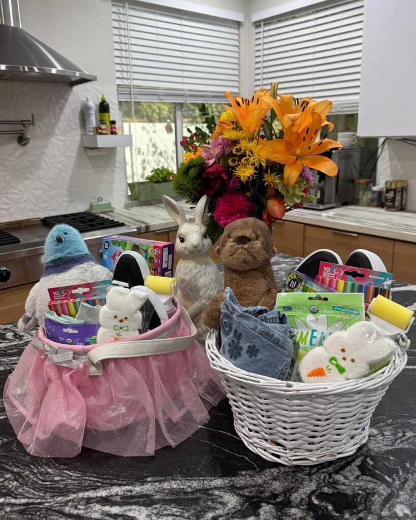 Two filled Easter baskets for kids with plush animals, candy, crayons, small toys, and spring clothing.