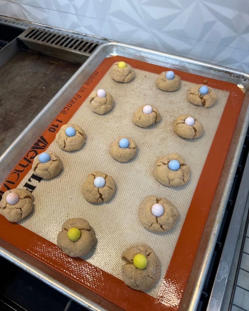pressing mini eggs into peanut butter blossom cookies