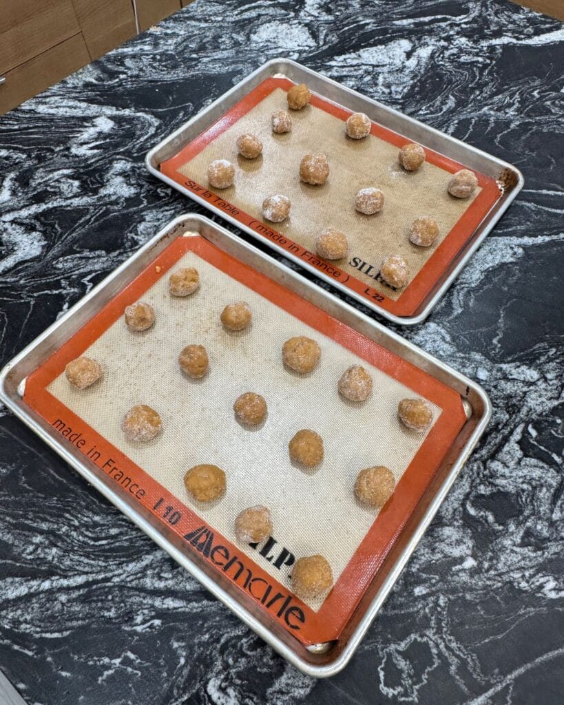 peanut butter cookie dough balls rolled in sugar before baking