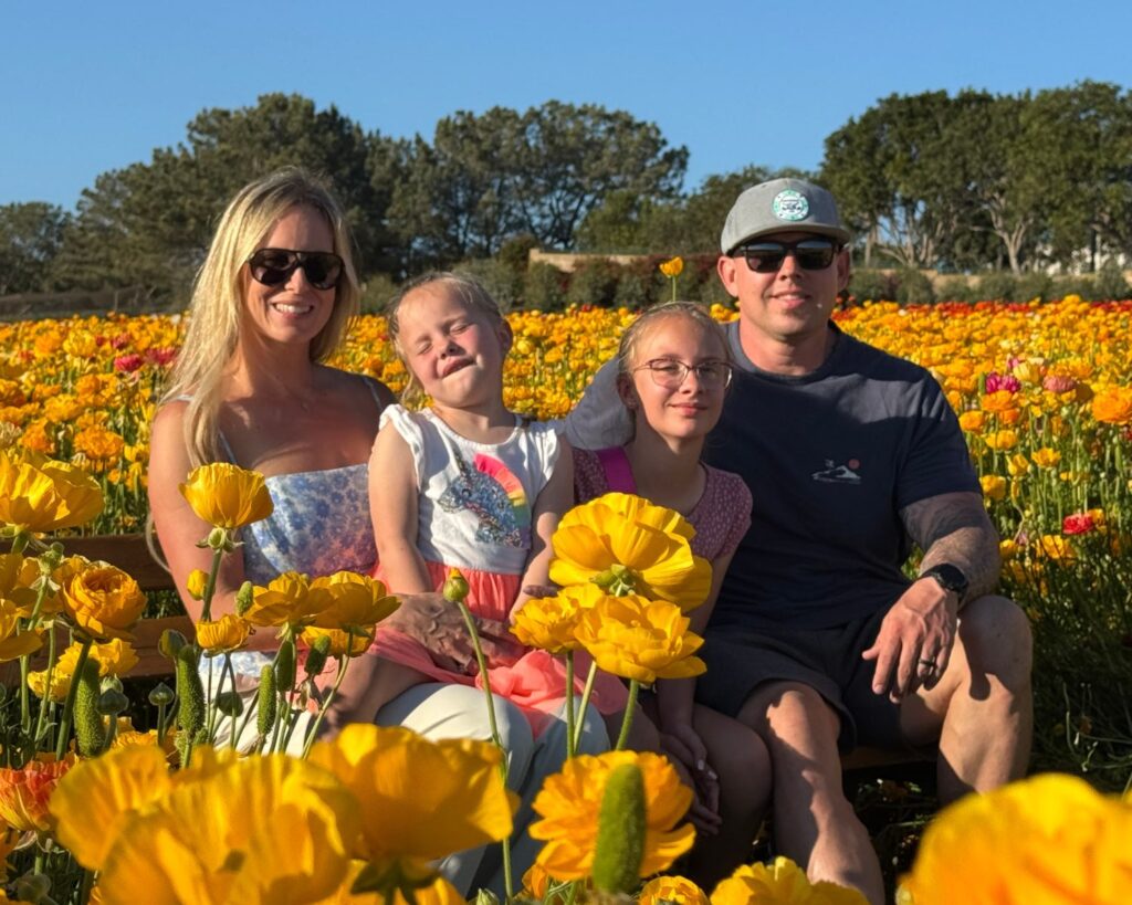 Family photo among the colorful ranunculus flowers at The Flower Fields in Carlsbad California