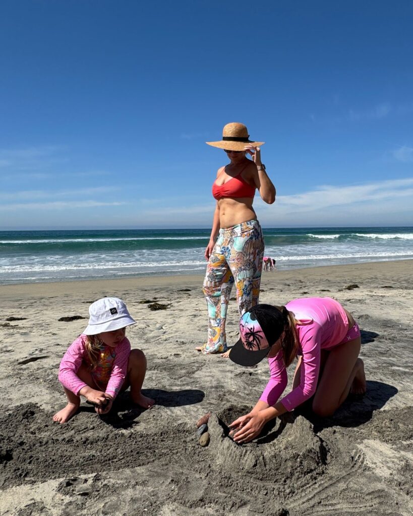 Mom and daughters building sandcastles on the beach in Carlsbad California
