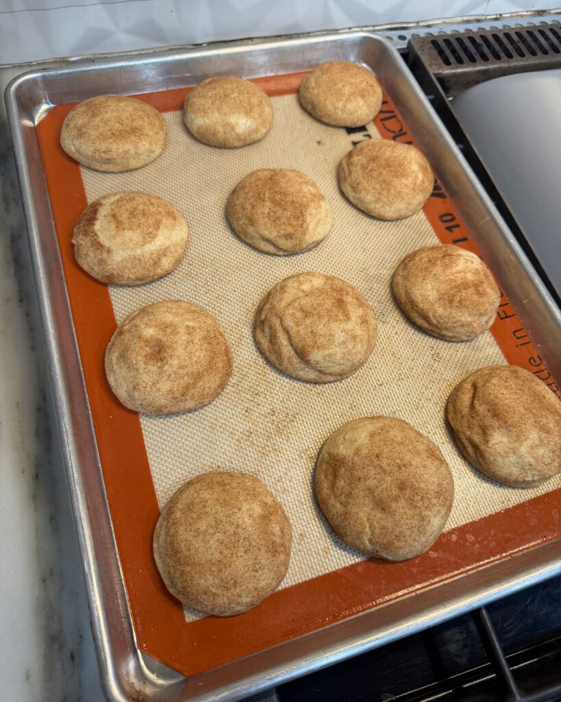 Fresh baked homemade snickerdoodle cookies cooling on a baking sheet