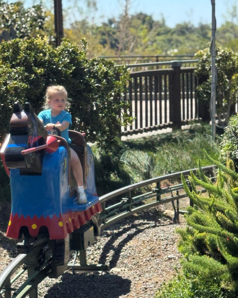 Young child riding pony ride attraction at LEGOLAND California theme park