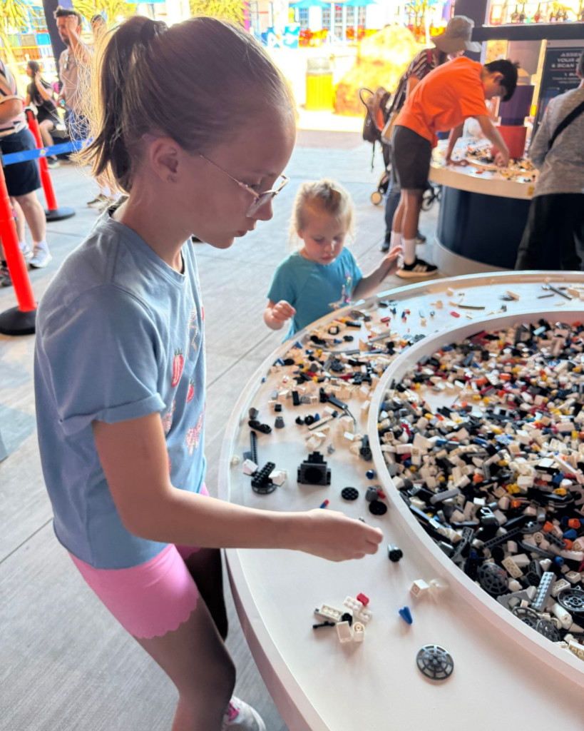 Kids building LEGO creations at play table inside LEGOLAND California Resort