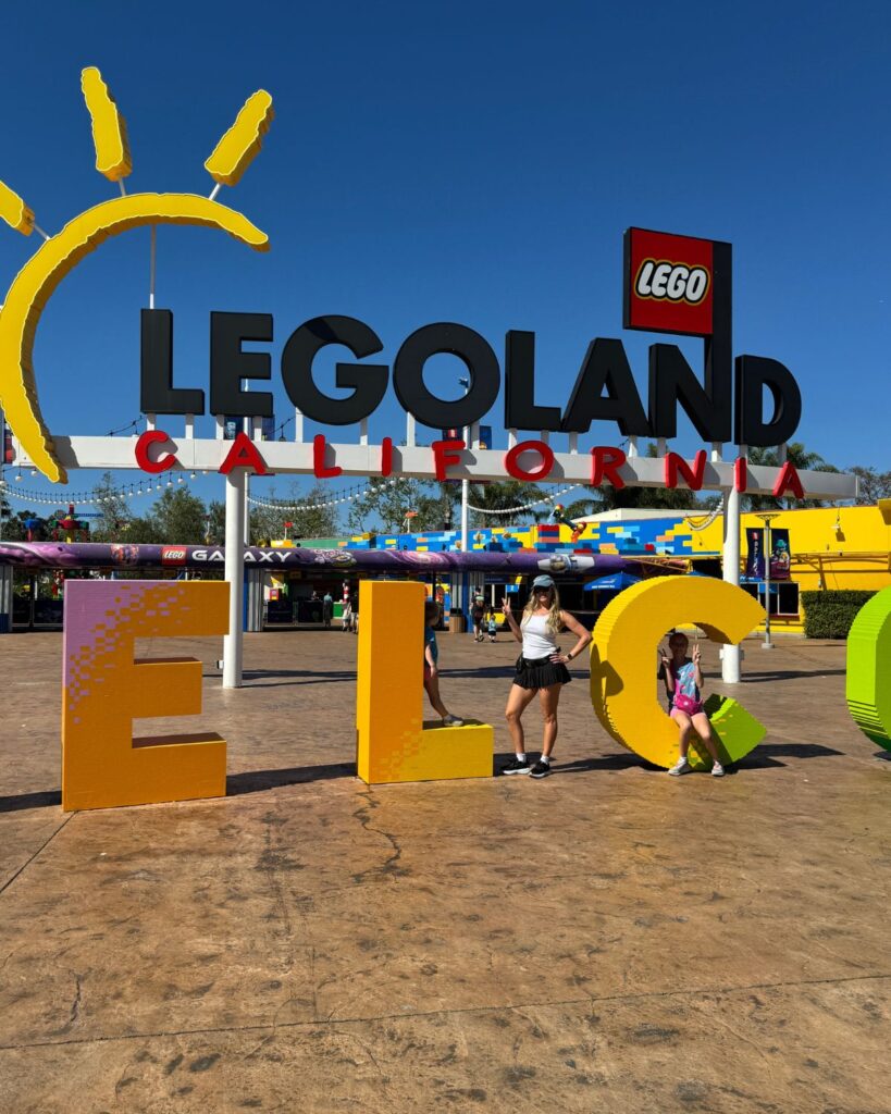 Family posing in front of the LEGOLAND California entrance sign