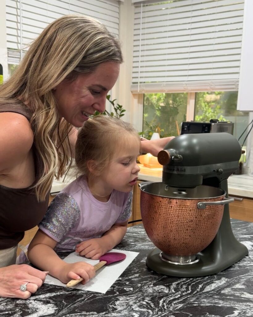 Mom and daughter baking homemade snickerdoodle cookies together in the kitchen