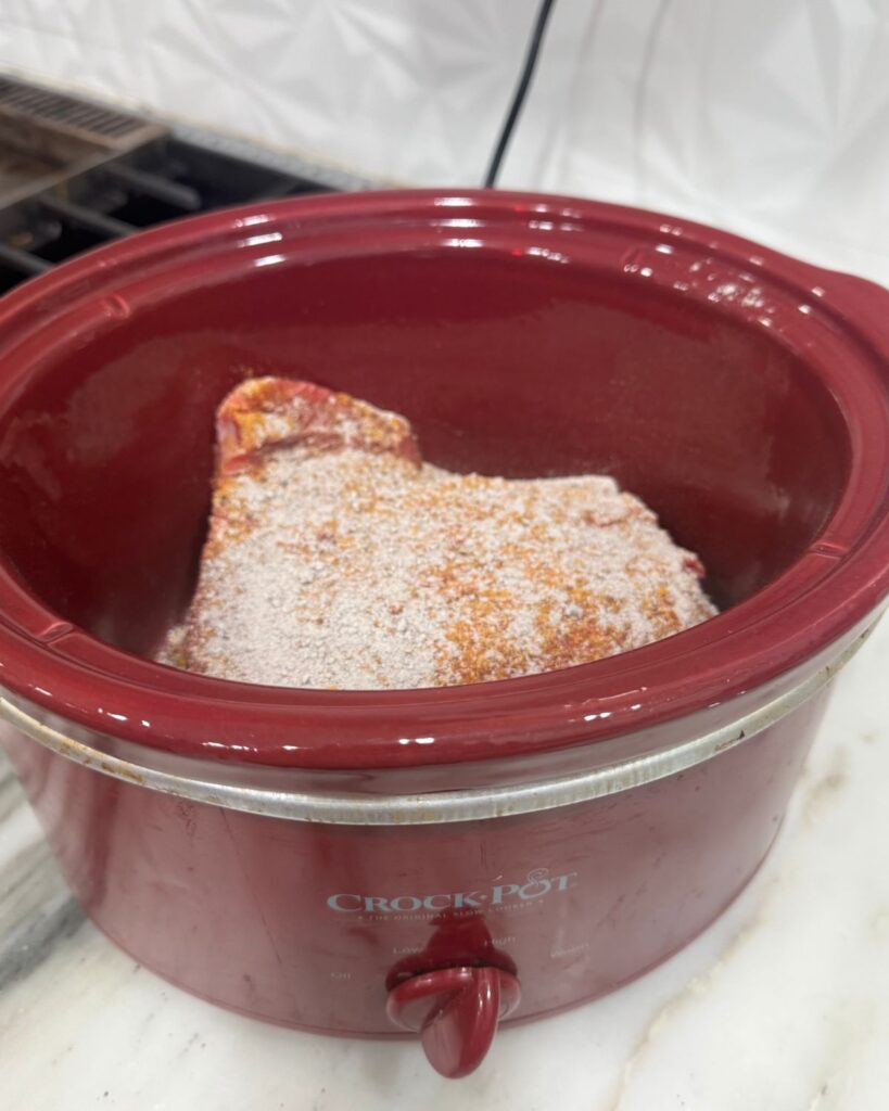 Seasoned chuck roast placed in crockpot to make slow cooker birria