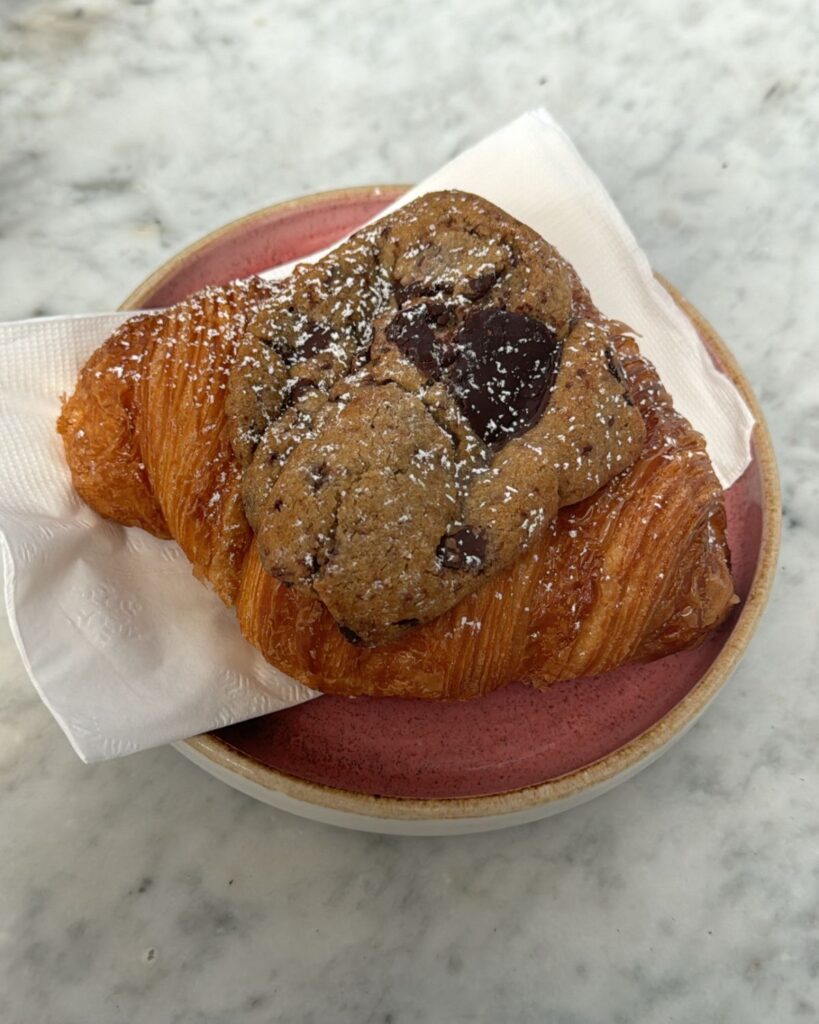 Chocolate chip cookie served on top of a flaky croissant at Parakeet Cafe in La Jolla.