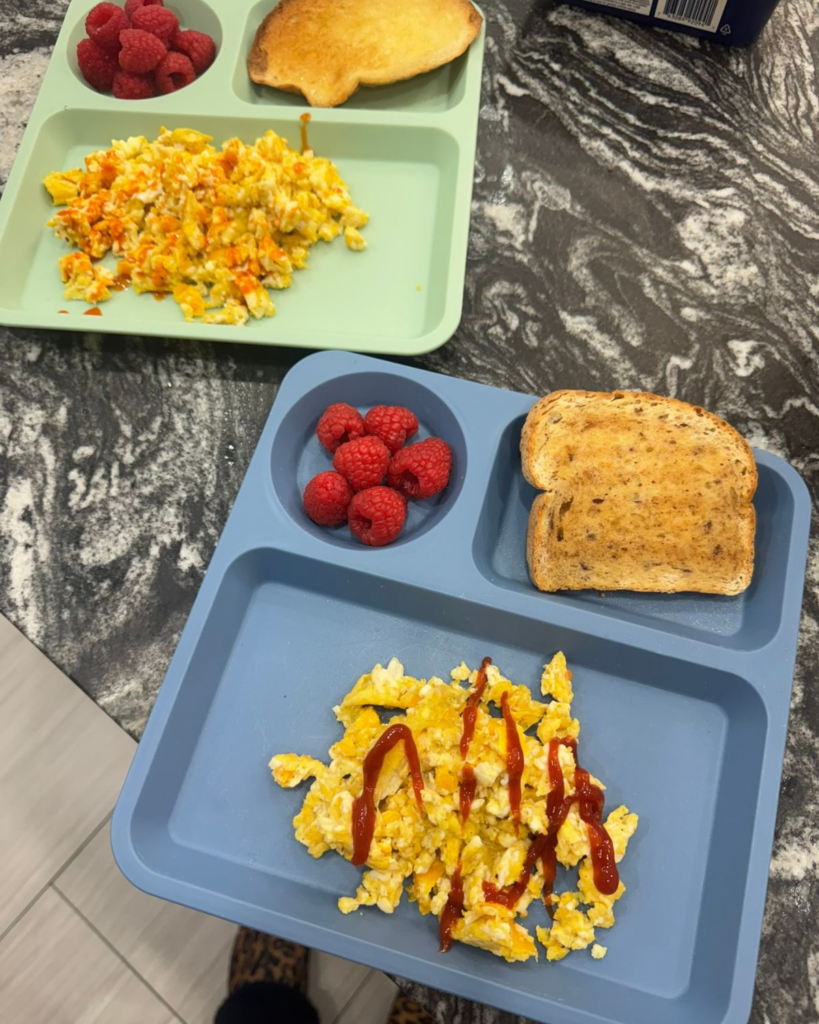 Simple kid-friendly breakfast with scrambled eggs, toast, and raspberries during a realistic summer morning routine for moms.
