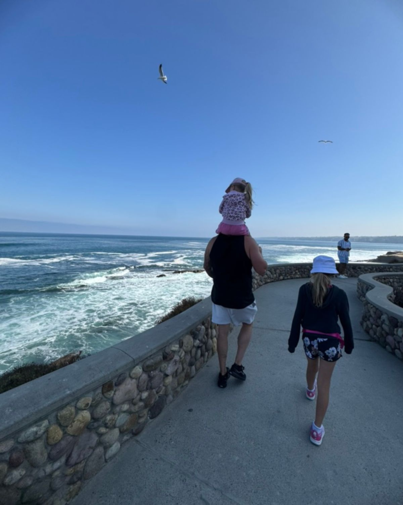 Family walking along the ocean in Southern California during a summer family trip.