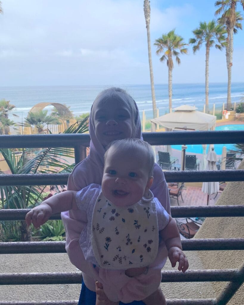 two girls on the balcony of an oceanfront room at pacific terrace in pacific beach