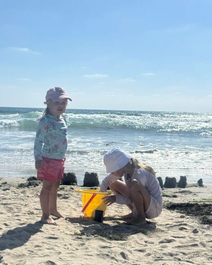 two girls building a sand castle in pacific beach