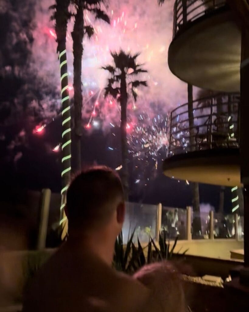 dad holding daughter watching fireworks from their hotel patio at pacific terrace in pacific beach