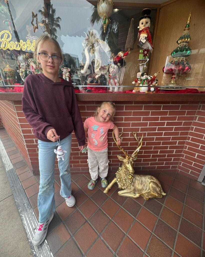 two girls in La Jolla village holding Santa ornaments