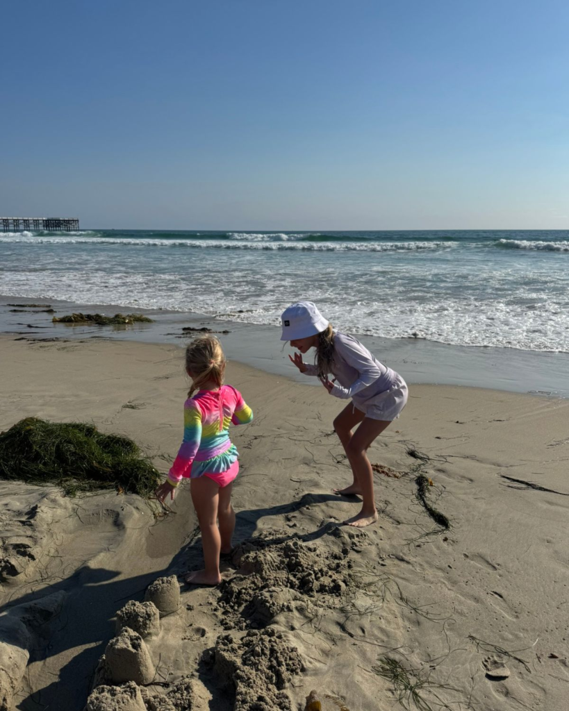 two girls playing in the sand at pacific beach