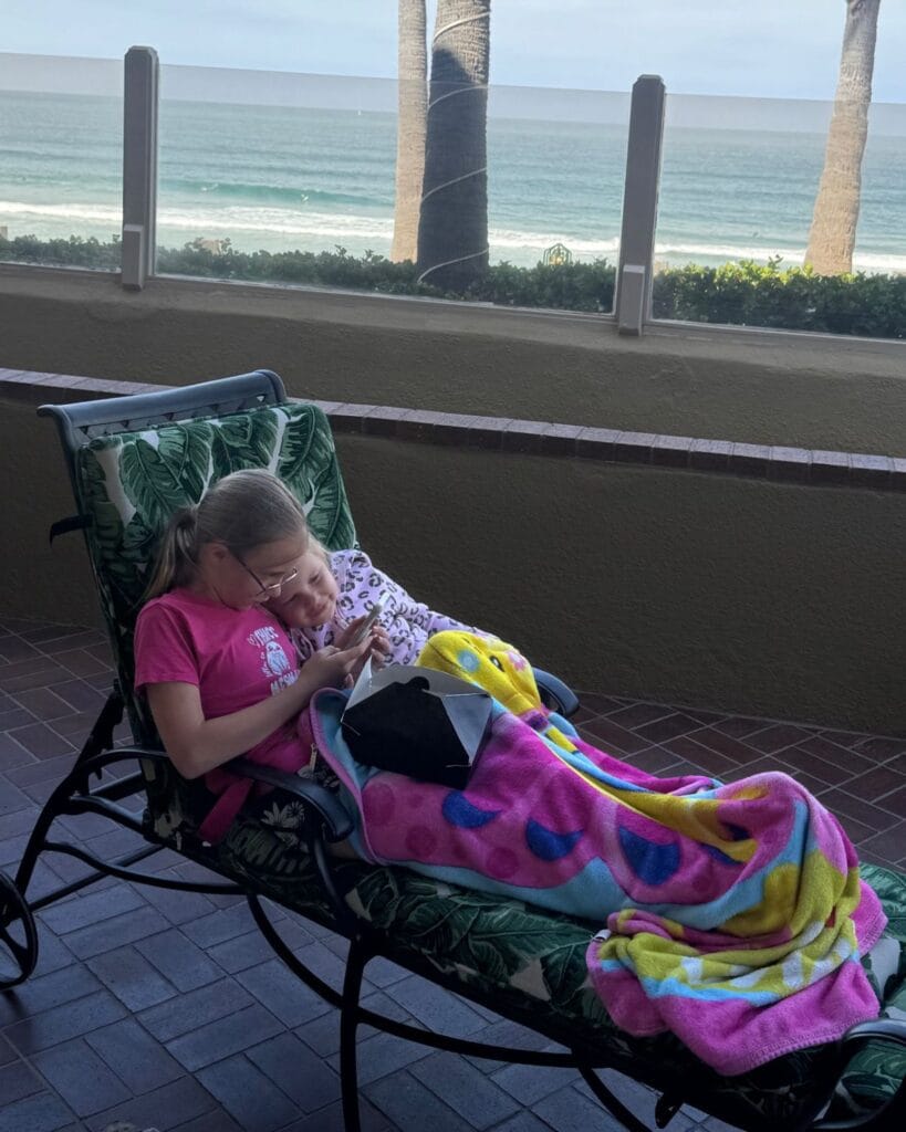 two girls cuddling on the patio of their room at pacific terrace in pacific beach