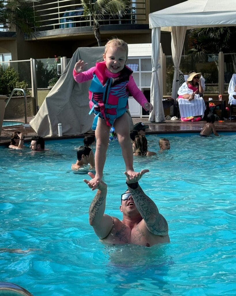 dad playing with daughter in the pool at pacific terrace in pacific beach