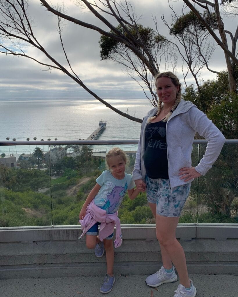 mom and daughter with ocean behind them at Birch Aquarium at Scripps
