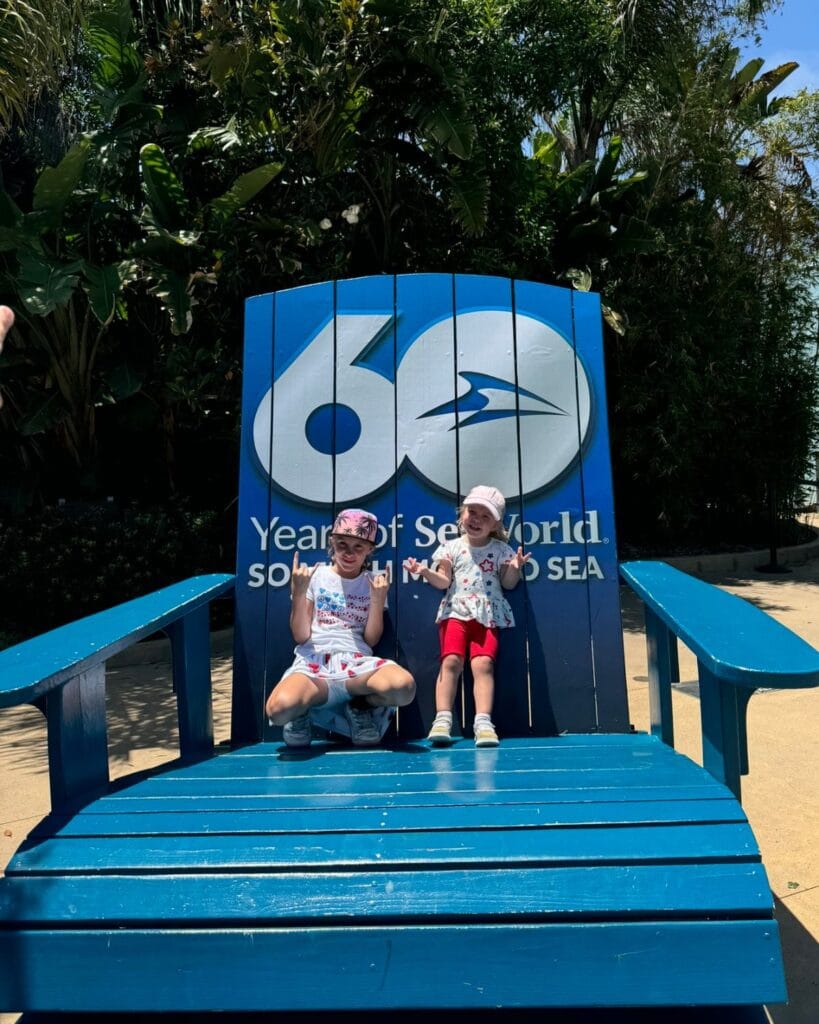 two girls sitting on a oversized chair for sea worlds 60th anniversary
