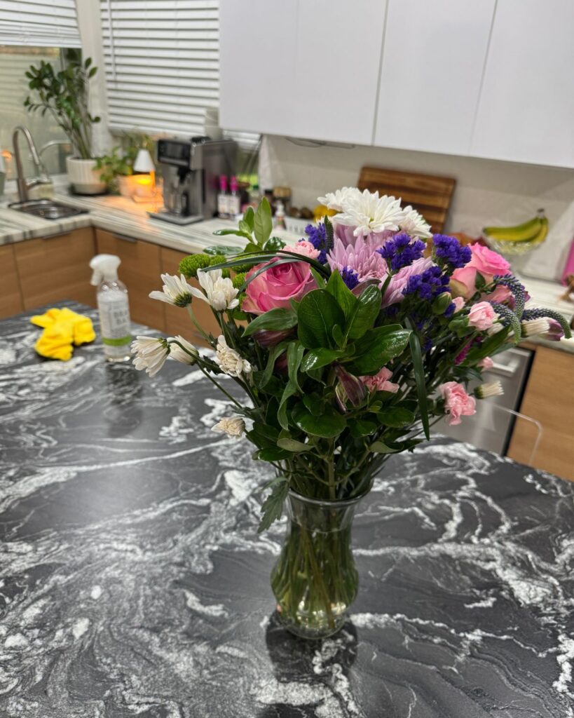 clean kitchen with fresh flowers on the island and candle warmer on