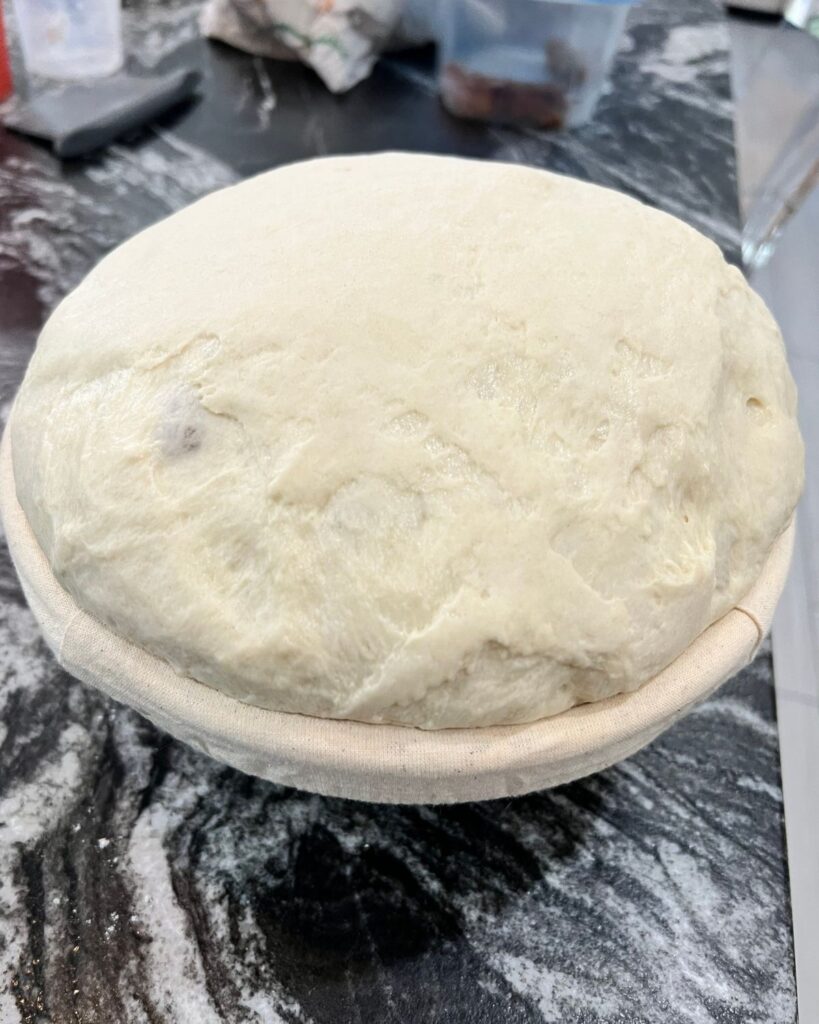 Sourdough dough after bulk fermentation resting in a banneton basket before baking.