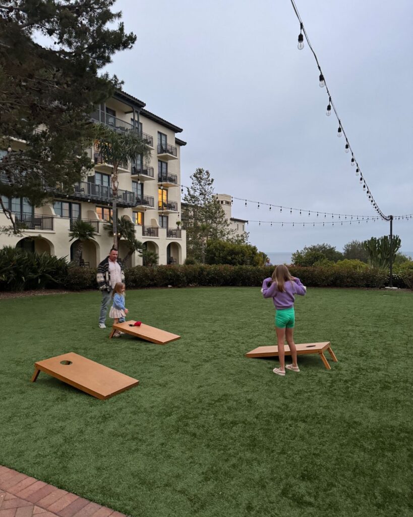 dad with daughters playing corn hole at Terranea Resort