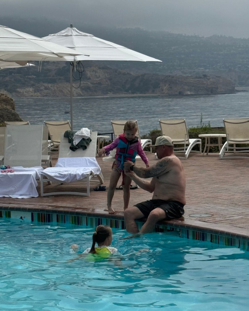 Dad with daughters at resort pool in Terranea Resort