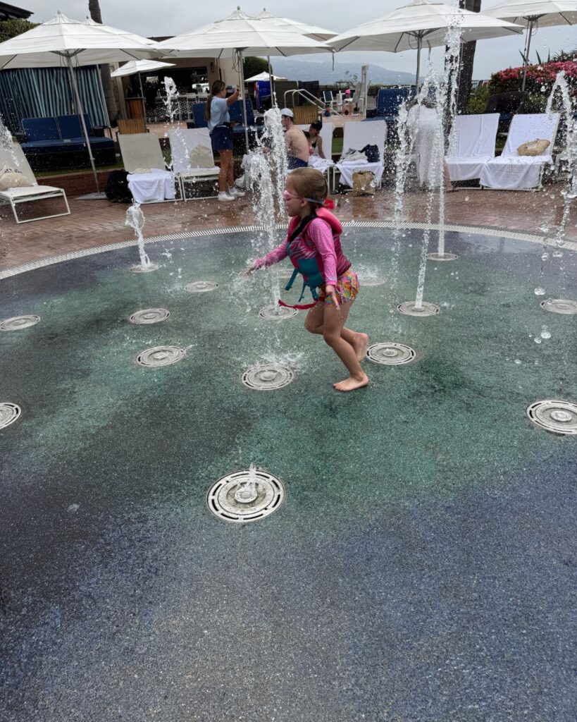 Girl running through splash pad at Terranea Resort