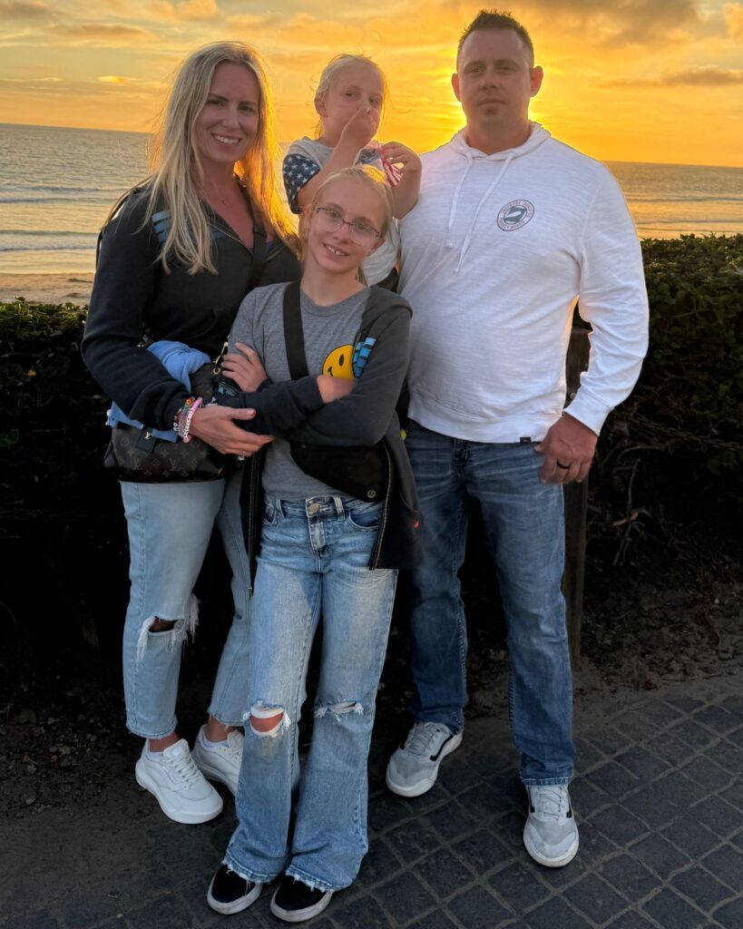 Family photo at sunset overlooking the beach outside Pacific Terrace Hotel.