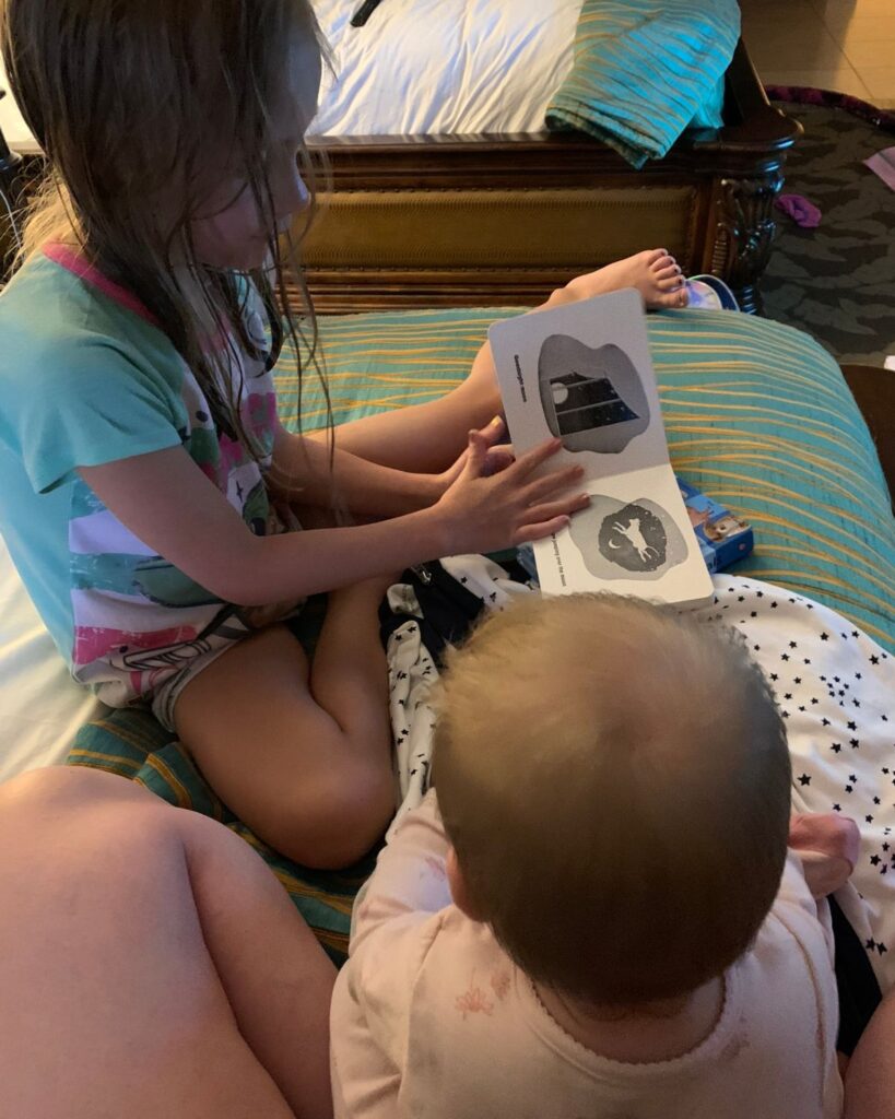 Sisters reading books together in the Family Suite at Pacific Terrace Hotel.