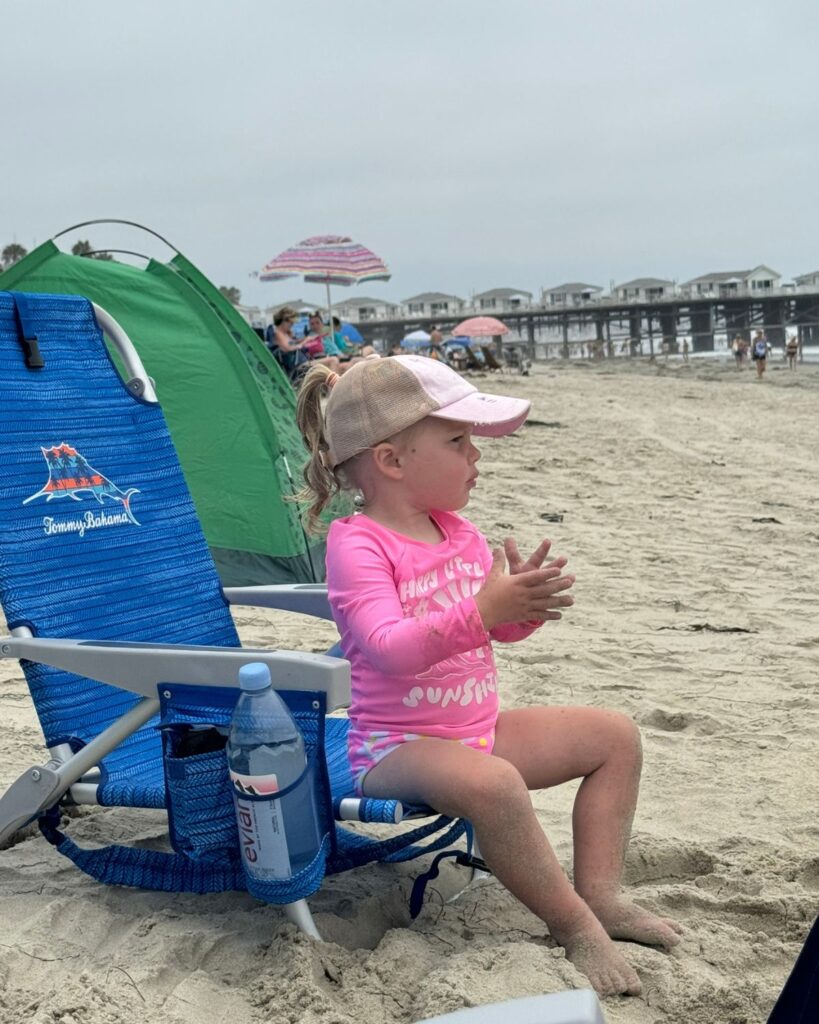 Child relaxing in complimentary beach chairs provided by Pacific Terrace Hotel.