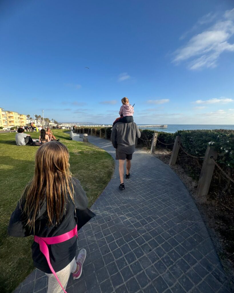 Walking the Pacific Beach boardwalk directly in front of Pacific Terrace Hotel.