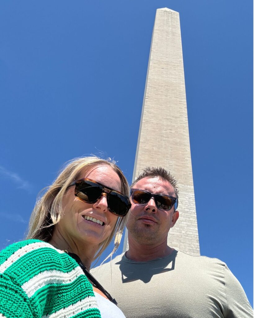 Couple standing in front of the Washington Monument during a Washington DC couples trip.