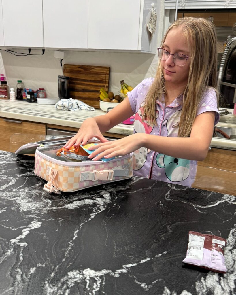 Elementary school student packing her lunch the night before school