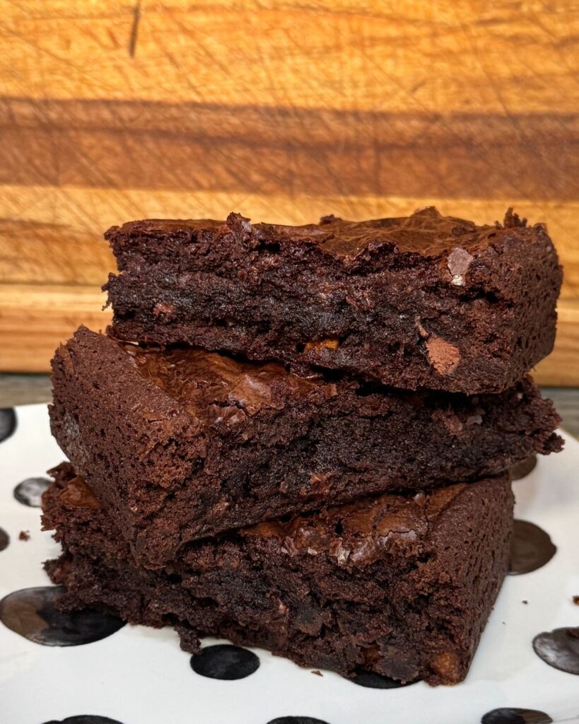 Stack of thick fudgy brownies made with Ghirardelli brownie mix, butter, and chocolate chips.
