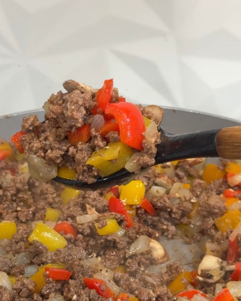 Seasoned ground beef with sautéed bell peppers, onions and mushrooms for loaded cheesesteak bowls