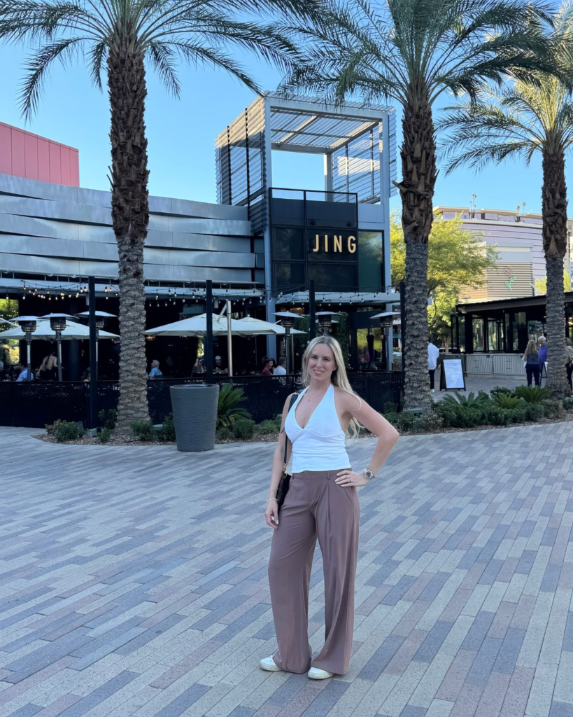 Julie standing outside a restaurant six weeks after breast lift and implant exchange surgery
