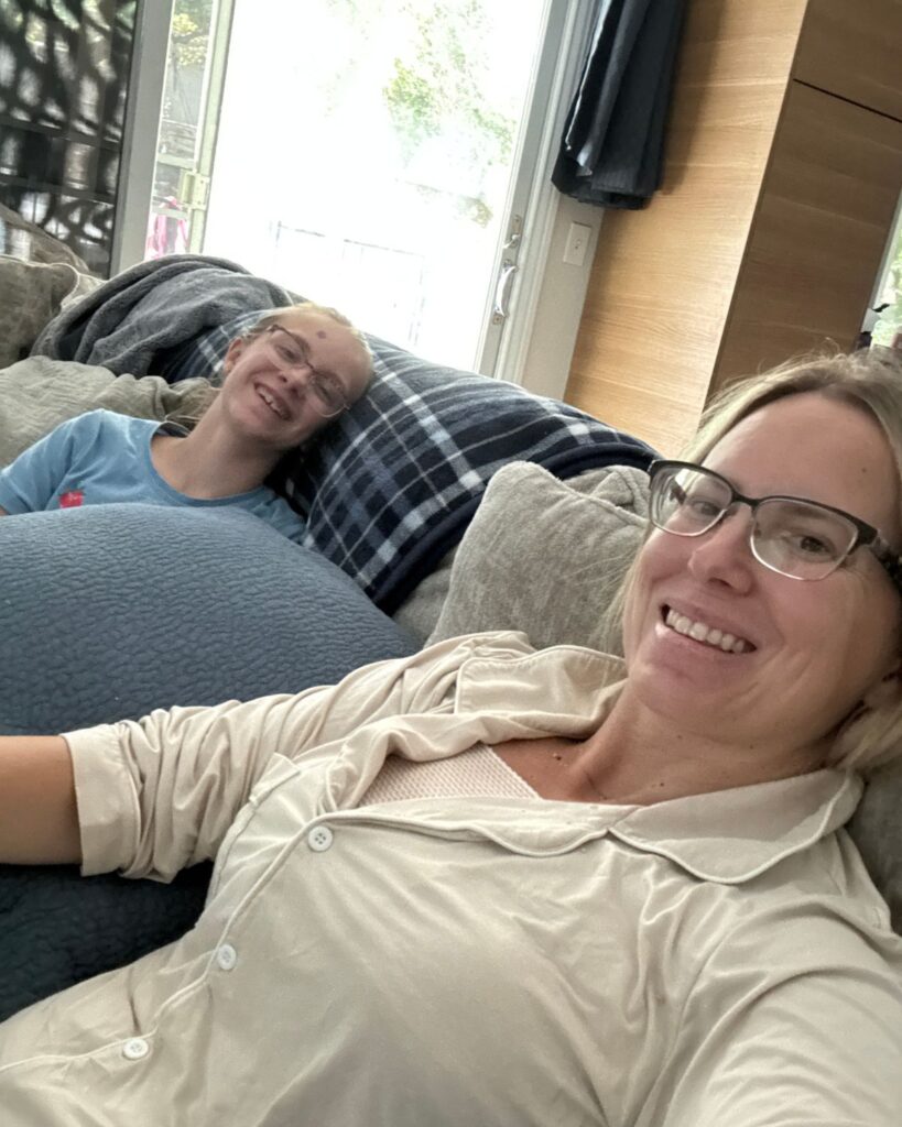 Julie resting on the couch with her daughter during the first week after breast surgery