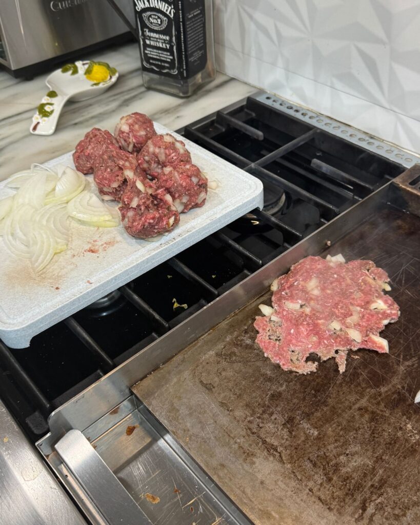 Seasoned ground beef portions ready to be smashed and cooked on a flat griddle