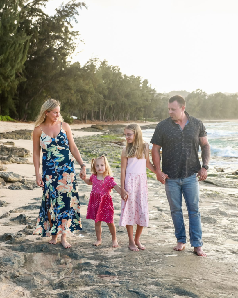 family walking along the beach in hawaii holding hands