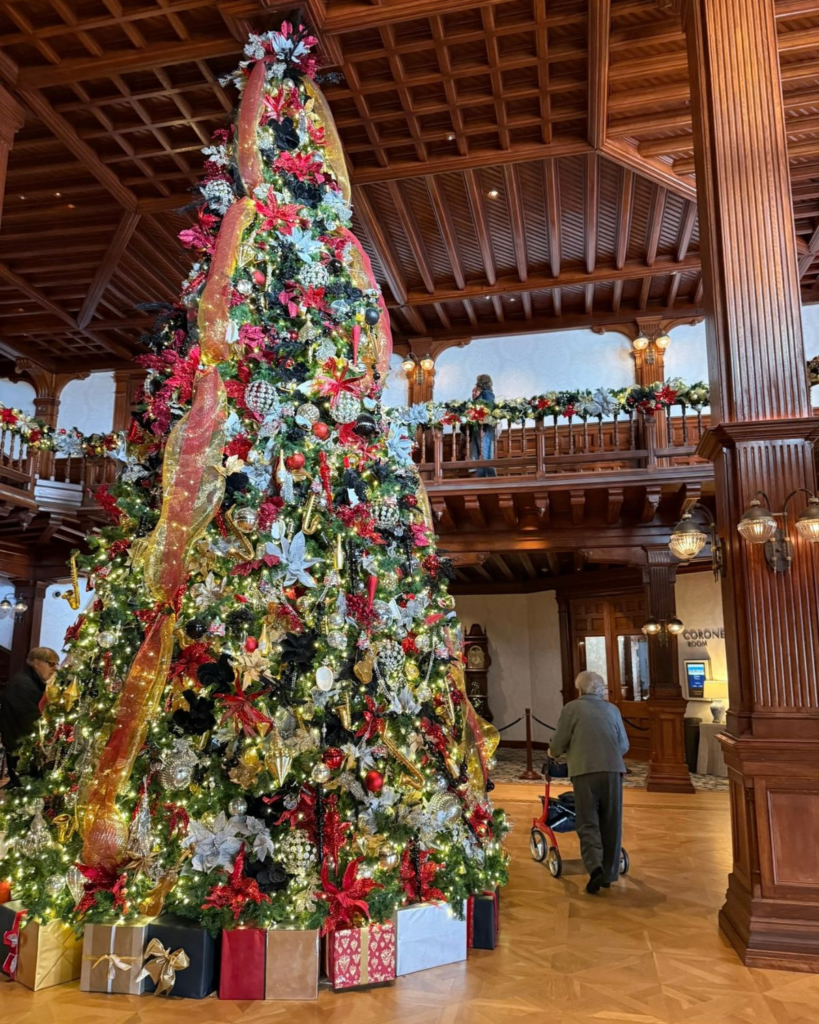 Large Christmas tree decorated with red and gold ornaments inside Hotel Del Coronado