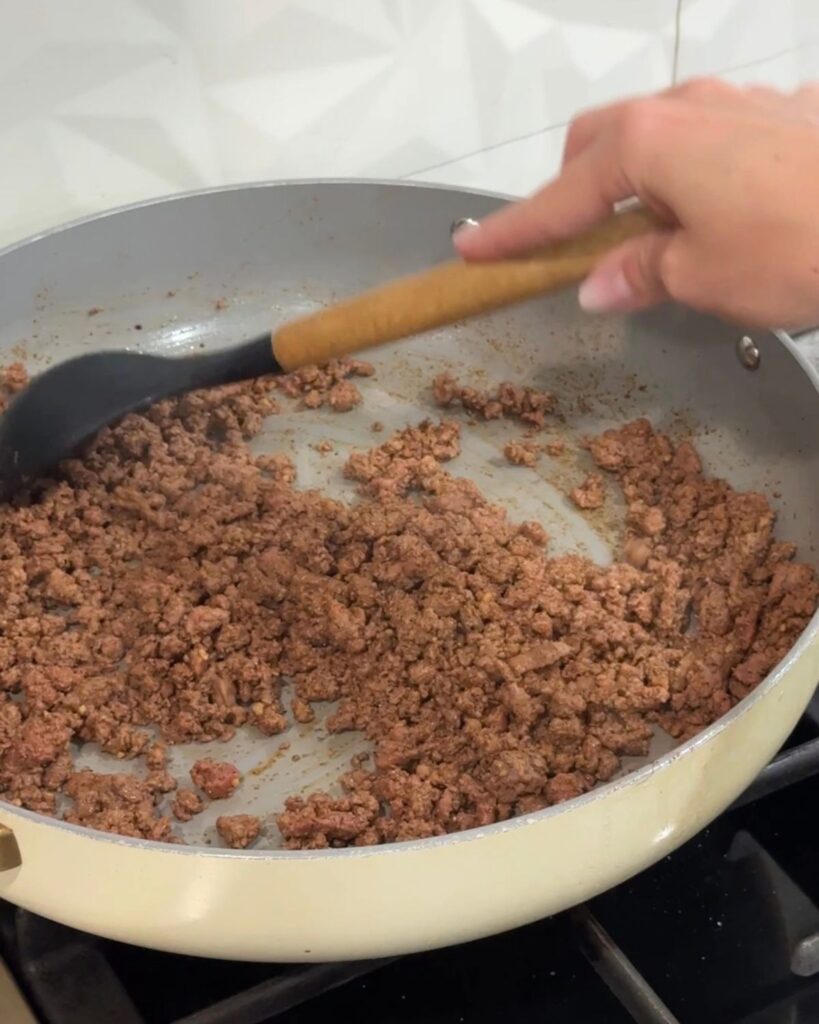 Ground beef cooking in a skillet for the crunchwrap filling