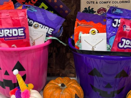 Two Halloween boo baskets with candy, books, small gifts, and festive items for kids