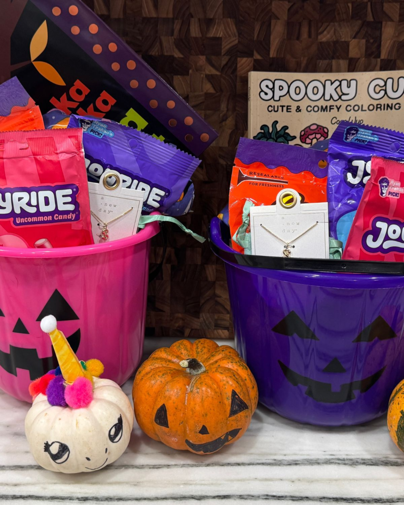 Two Halloween boo baskets with candy, books, small gifts, and festive items for kids